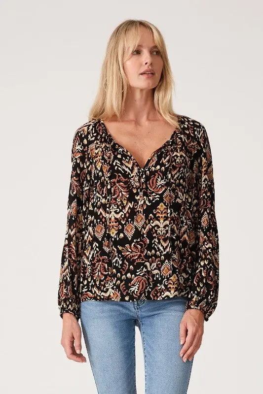A woman modeling the printed long sleeve tie neck blouse