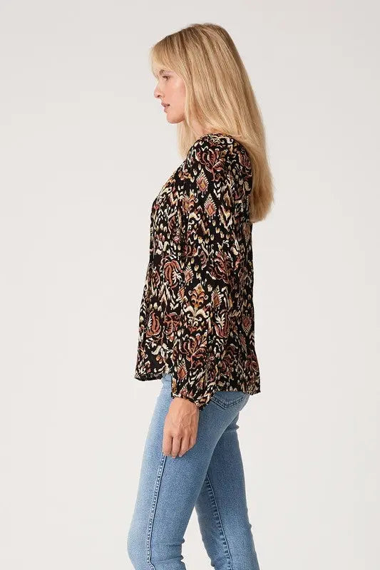 A woman modeling the printed long sleeve tie neck blouse