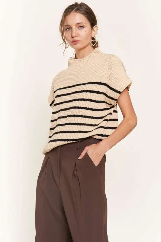 A woman modeling a beige striped sweater vest