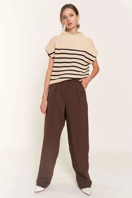 A woman modeling a beige striped sweater vest
