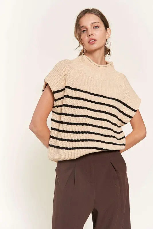 A woman modeling a beige striped sweater vest
