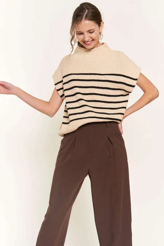 A woman modeling a beige striped sweater vest