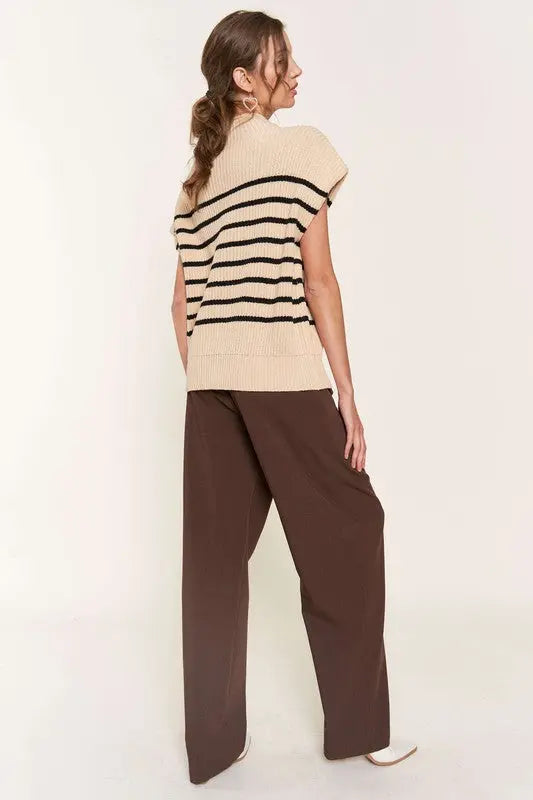 A woman modeling a beige striped sweater vest