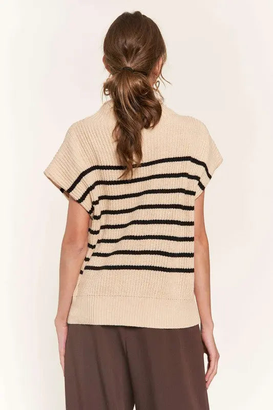 A woman modeling a beige striped sweater vest