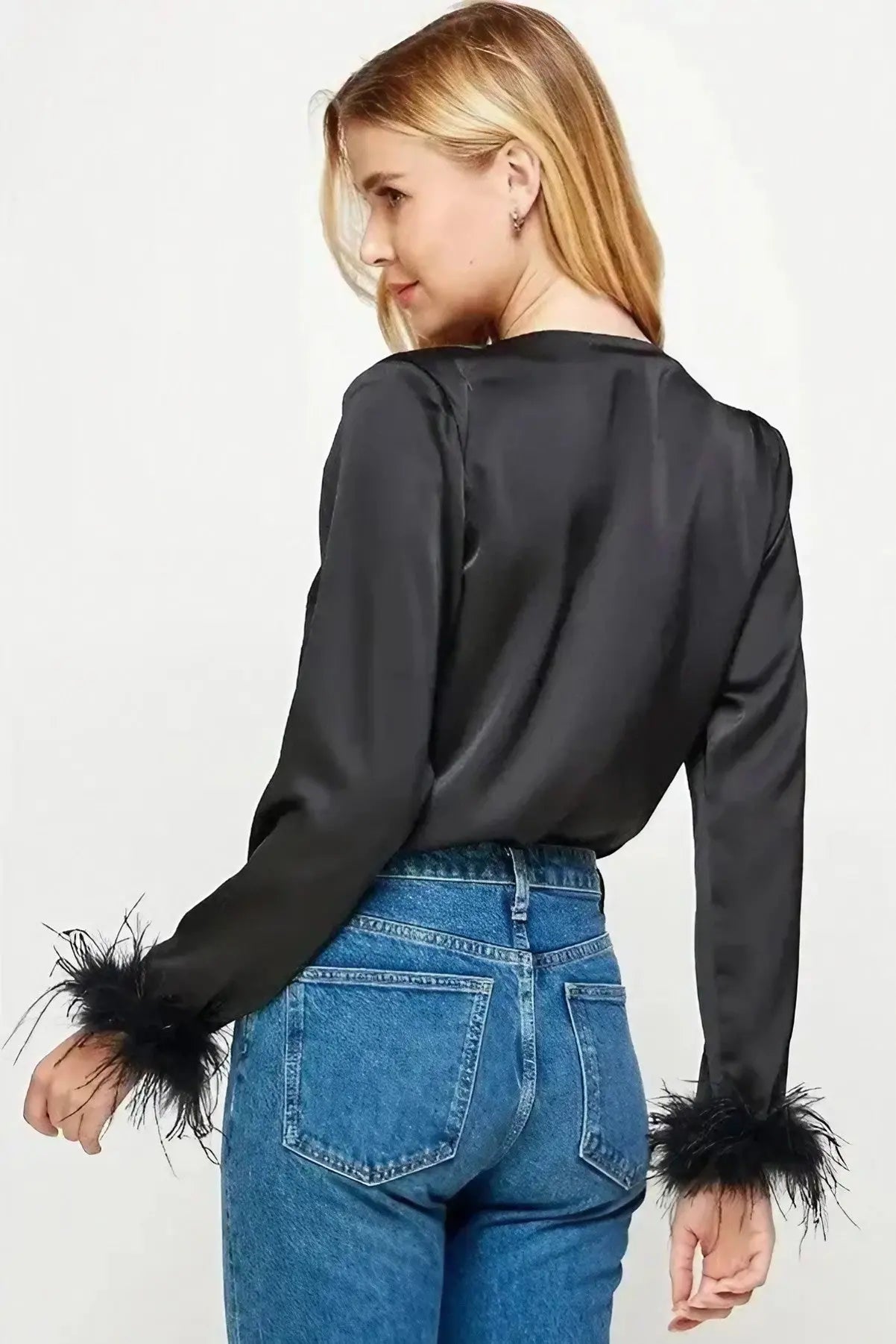 A model showcasing a black satin bodysuit with feather trim sleeve detail for women