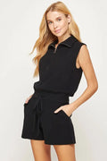 A female model showcasing the Black Half Zip Sleeveless Knit Romper 