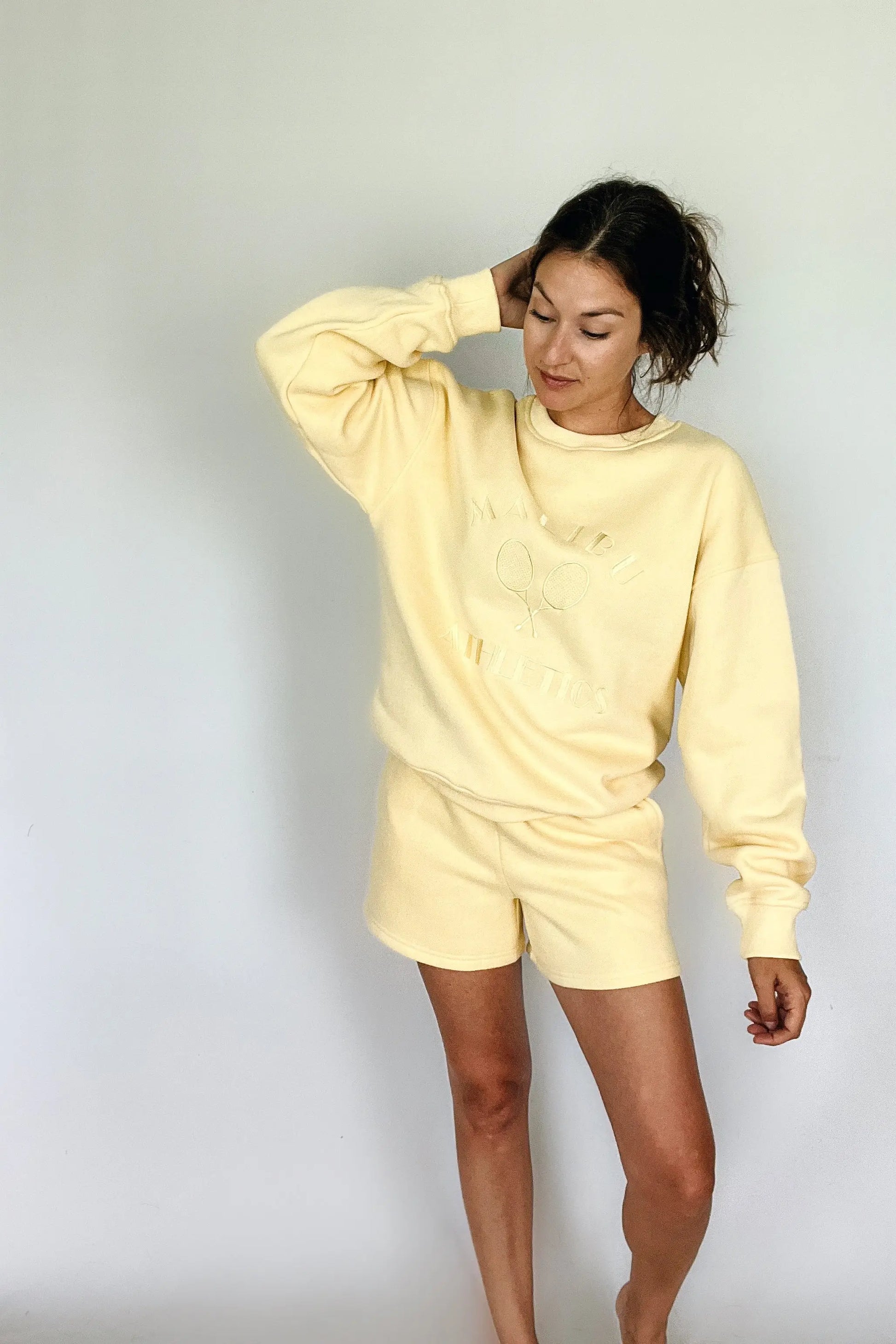 The Tiny Details modeling the Malibu Athletics Yellow Pullover Sweatshirt