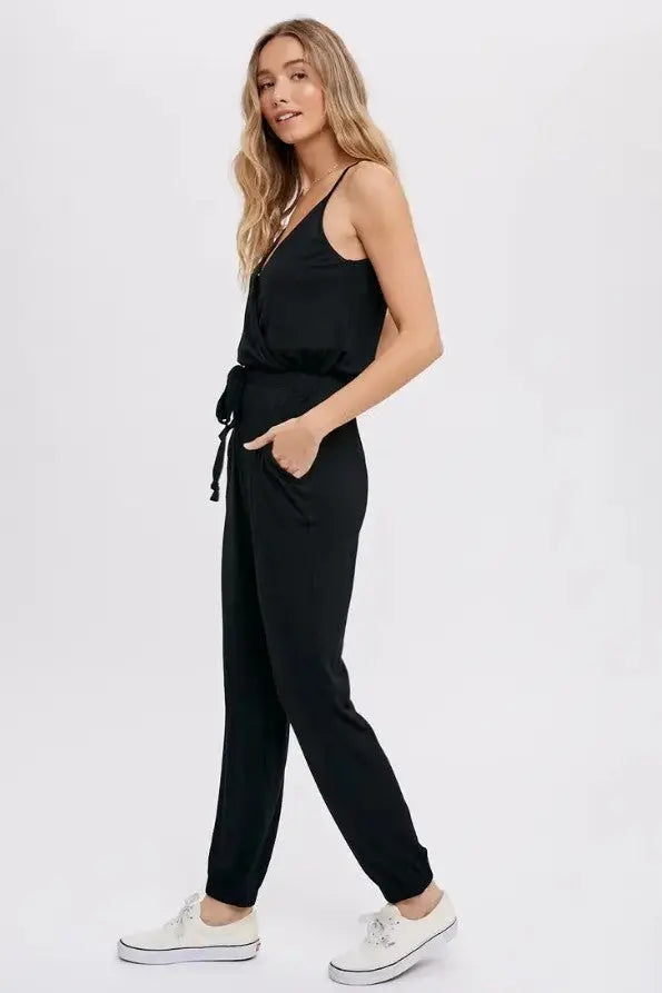 A woman modeling a black surplice casual jersey jumpsuit