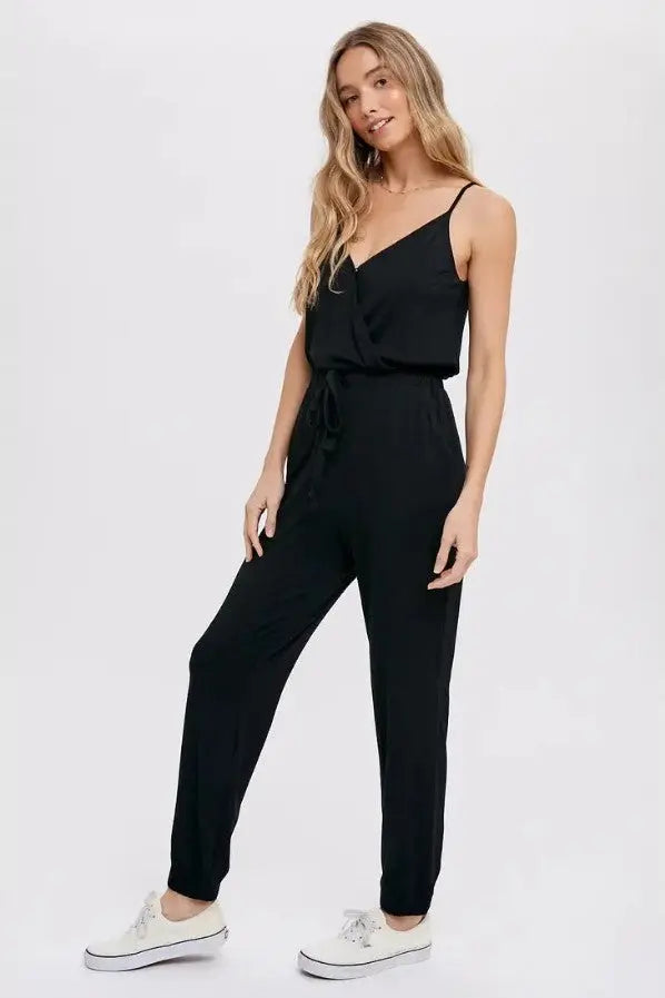 A woman modeling a black surplice casual jersey jumpsuit