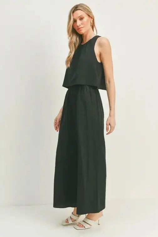 A female model showcasing a black wide-leg sleeveless jumpsuit