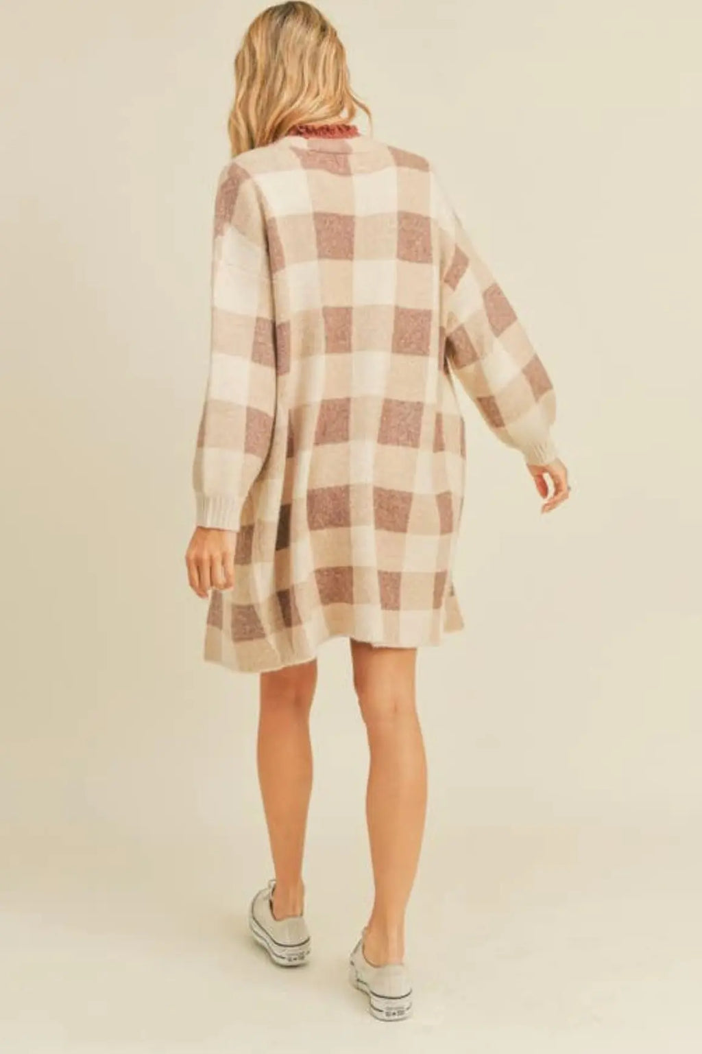 A woman modeling a ginger and cream plaid open cardigan