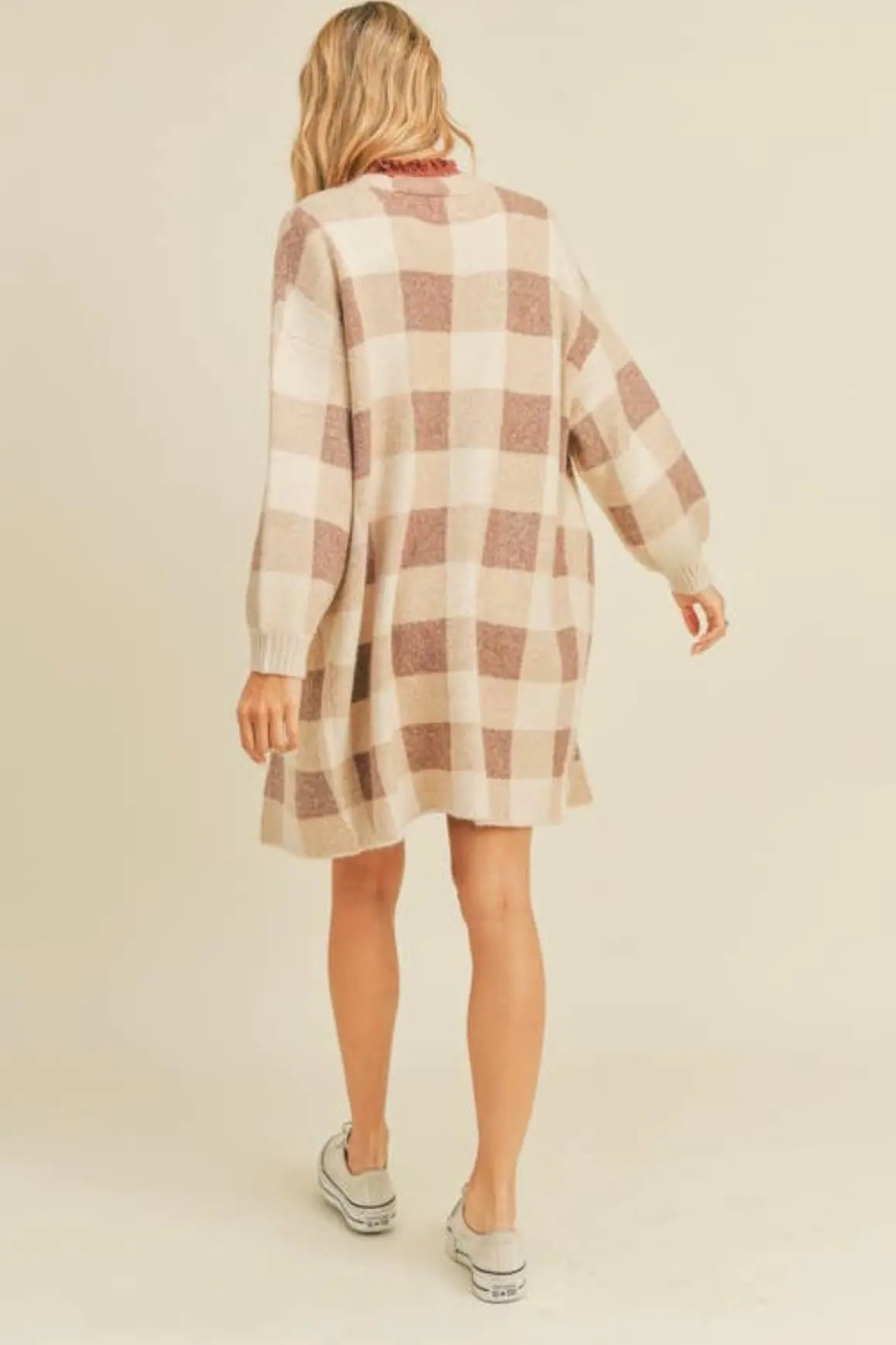 A woman modeling a ginger and cream plaid open cardigan