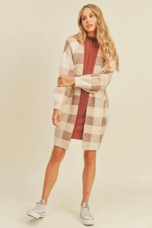 A woman modeling a ginger and cream plaid open cardigan