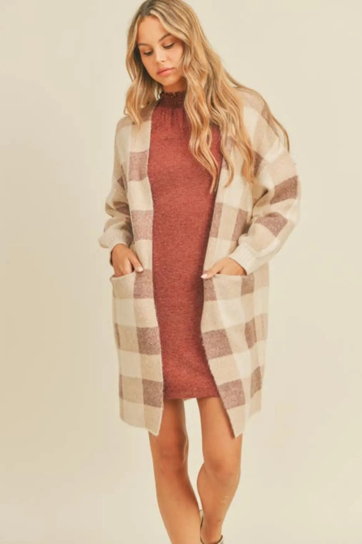 A woman modeling a ginger and cream plaid open cardigan