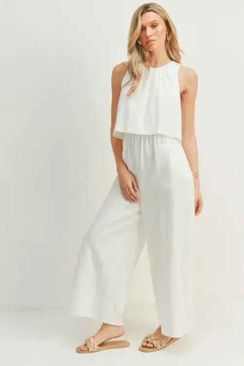 A woman modeling a white wide-leg sleeveless jumpsuit
