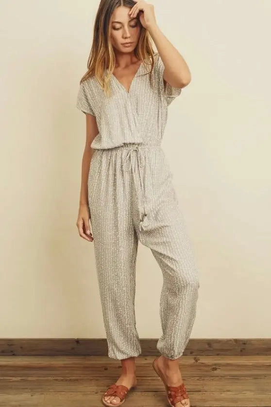 The Tiny Details modeling a pebbles print surplice jumpsuit for women