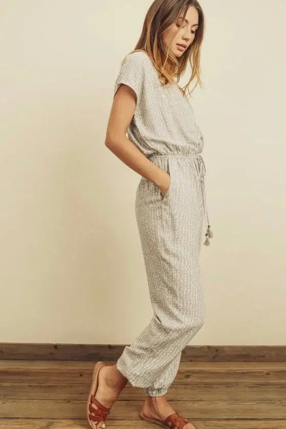 The Tiny Details modeling a pebbles print surplice jumpsuit for women