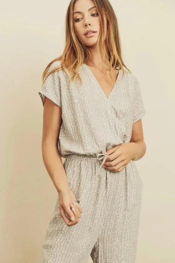 The Tiny Details modeling a pebbles print surplice jumpsuit for women