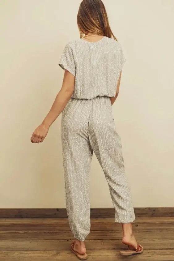 The Tiny Details modeling a pebbles print surplice jumpsuit for women