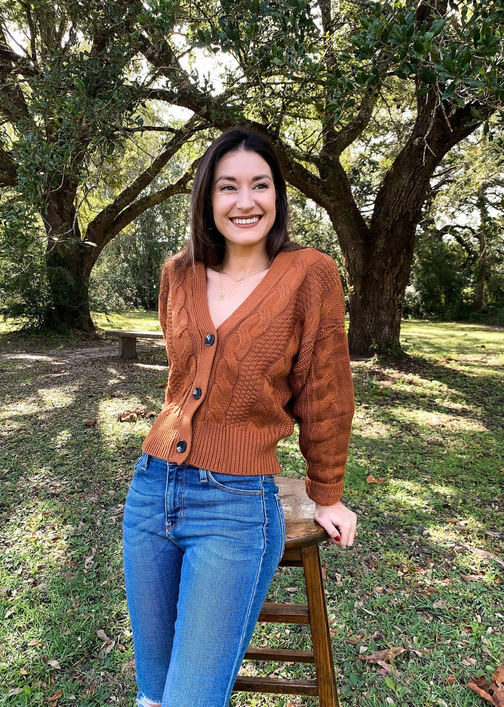 The Tiny Details modeling a terracotta chunky cable knit cardigan for womens fall fashion