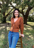 The Tiny Details modeling a terracotta chunky cable knit cardigan for womens fall fashion