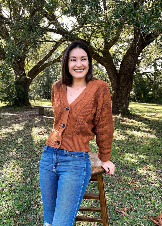 The Tiny Details modeling a terracotta chunky cable knit cardigan for womens fall fashion